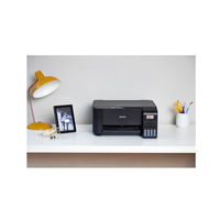 Epson printer on a desk with a lamp and photo frame in the background